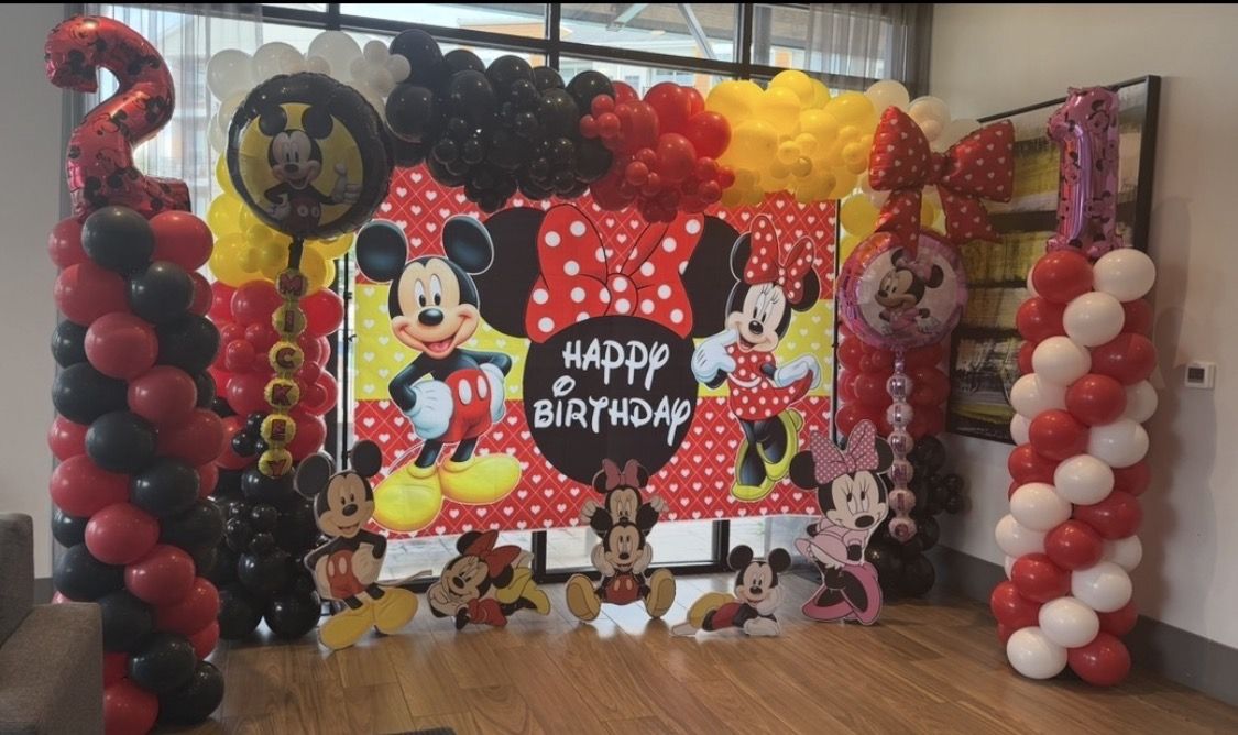 Themed birthday backdrop with balloon garland, columns and character cutouts